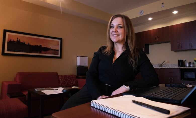 A woman sits at a desk.