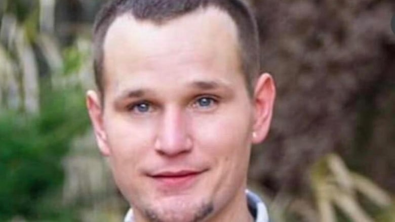 A man with short brown hair smiles for the camera.