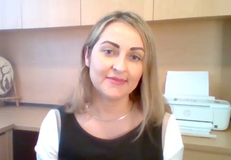 A woman sits in an office setting.