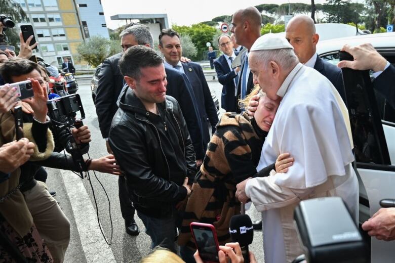 The Pope comforts a woman.