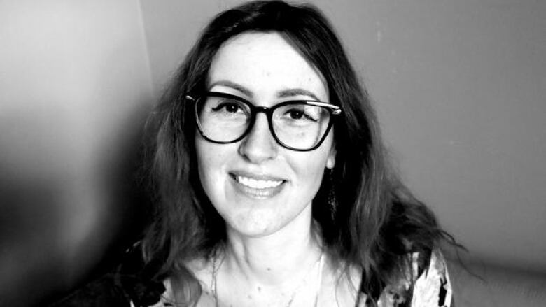 Black and white photo portrait of a woman with long hair and glasses