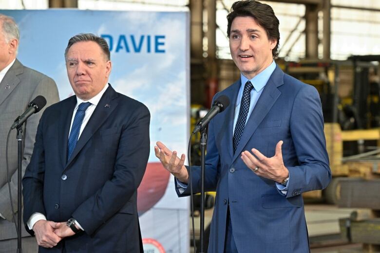 Prime Minister Justin Trudeau, right, responds to reporters' questions at a news conference after announcing major investments in shipbuilding on Tuesday, April 4, 2023 at the Davie shipyard in Levis, Que. Quebec Premier Francois Legault, left, looks on.