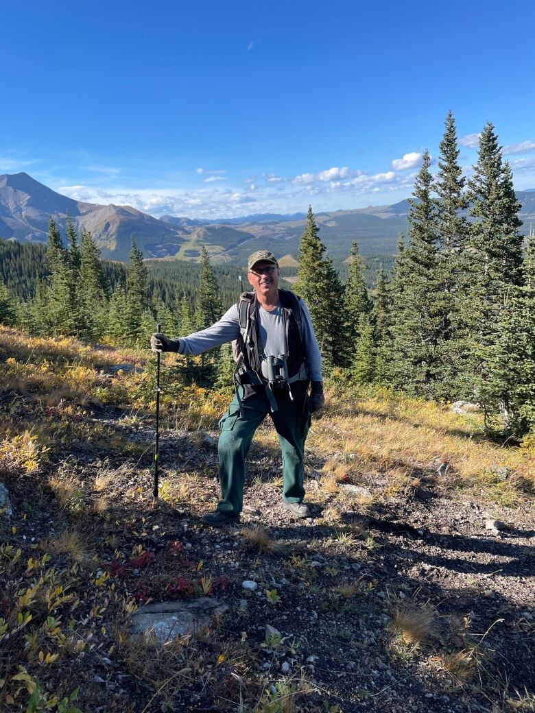 Man stands in front of an old mine near Cadomin 