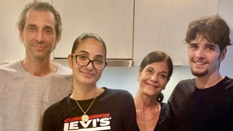 Chatzimanolakis family is seen in front of a birthday cake, from left to right: father George, sister Melissa, mother Lina and Anthony.