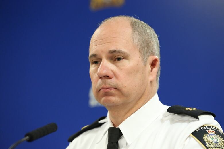 A police officer stares across the room during a news conference.