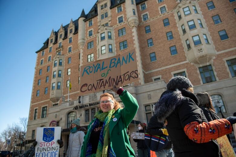 A person holds a sign that says 