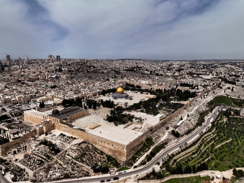 An aerial view of a city shows a religious compound and mosque.