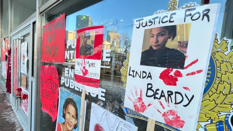 Signs that read 'justice for Linda Beardy' were posted on the windows of a police headquarters during a rally.