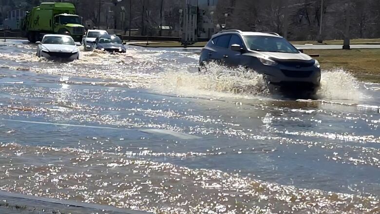 Cars go through a flooded roundabout in Halifax, N.S.