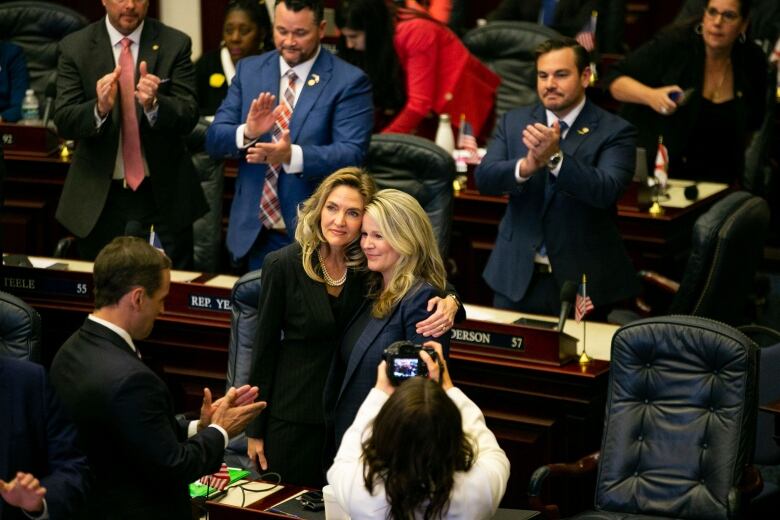 Two state representatives embracing in the Florida legislature, following the passing of  a bill banning abortion after six weeks of pregnancy.