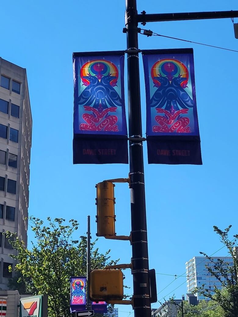 Two colourful street banners hang on lampposts