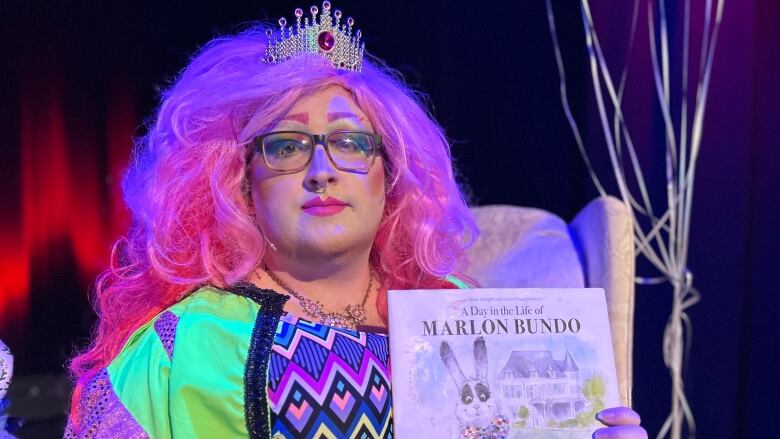 Tanner MacKinnon, performing as Lady Fefe Fierce, with the books A Day in the Life of Marlon Bundo, by Jill Twiss, and I Am Me: A Book of Authenticity, by Susan Verde