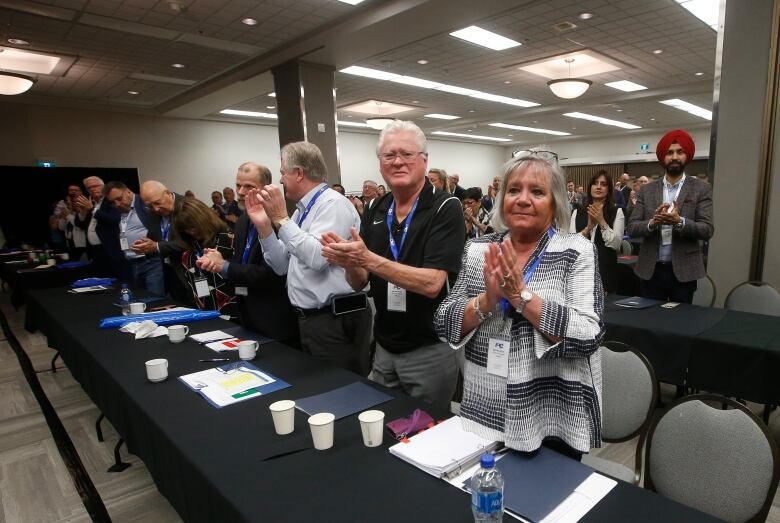 Delegates at the Progressive Conservative convention stand up and clap. 