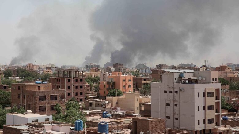 Smoke rises above buildings.