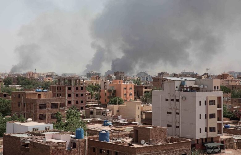 Smoke rises above buildings.