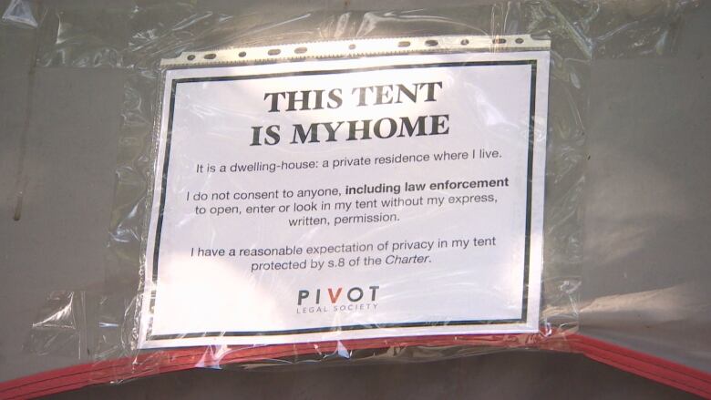 A poster by Pivot Legal on a tent