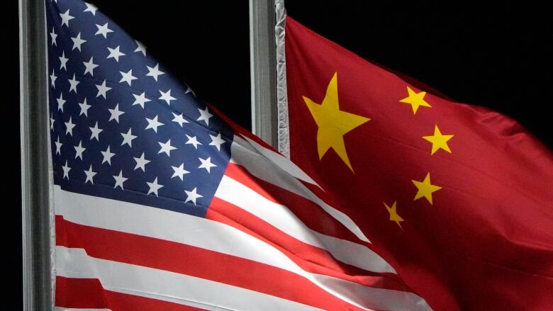 The American and Chinese flags are seen waving on flag poles.