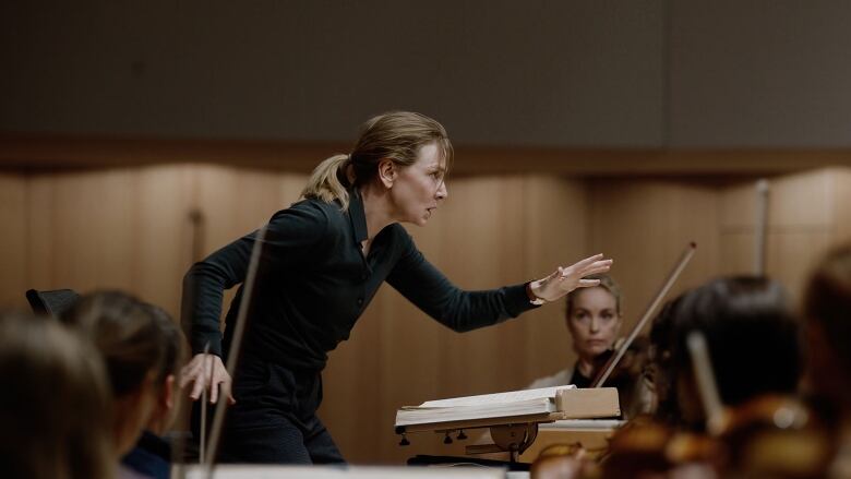 Still frame from the film Tr. Cate Blanchett conducts an orchestra with great intensity.