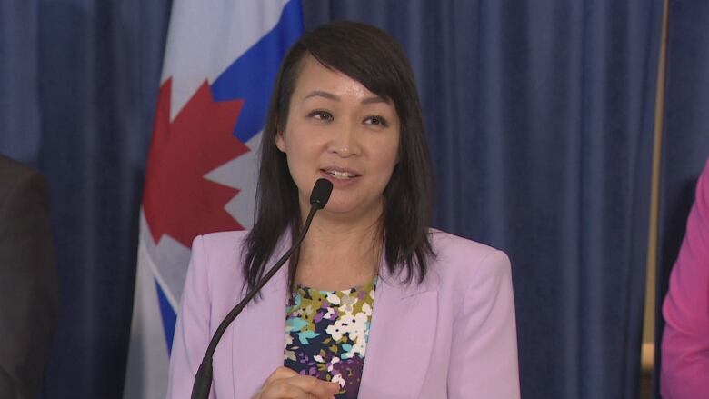  Coun. Lily Cheng stands at a podium 