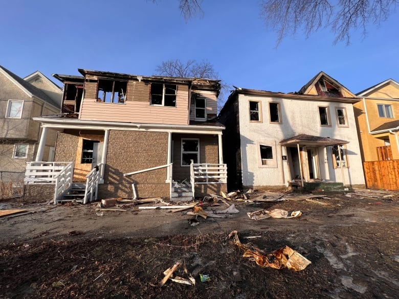 Two burnt-out duplexes are seen with roofs and windows after a fire on Tuesday.