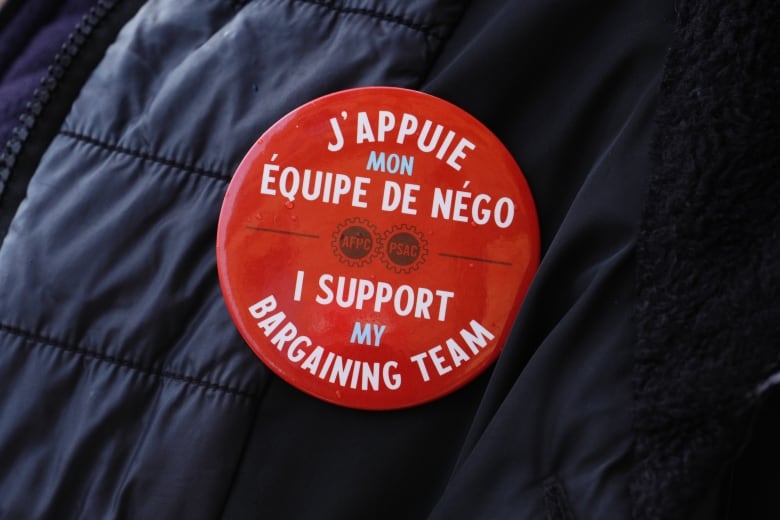 A red button supporting striking workers in both English and French.