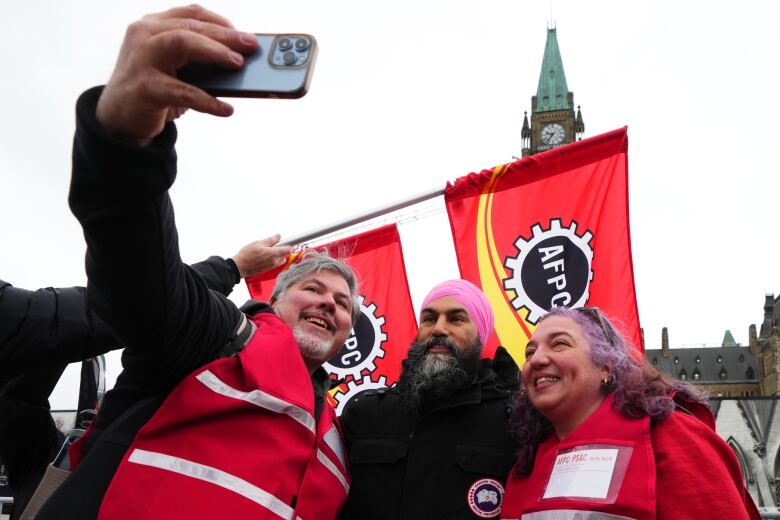 NDP Leader Jagmeet Singh is pictured taking a photo with striking workers on Parliament Hill.