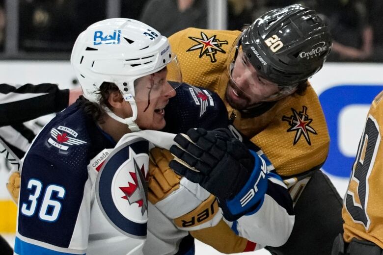 A Golden Knights player looks on in concern as a Winnipeg Jets player bleeds from his right temple.