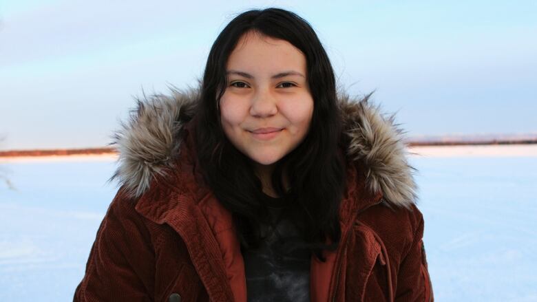 A young Inuk is shown wearing a traditional parka. 