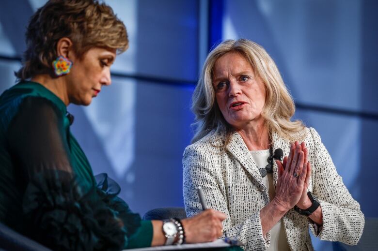 Two women talk on stage.