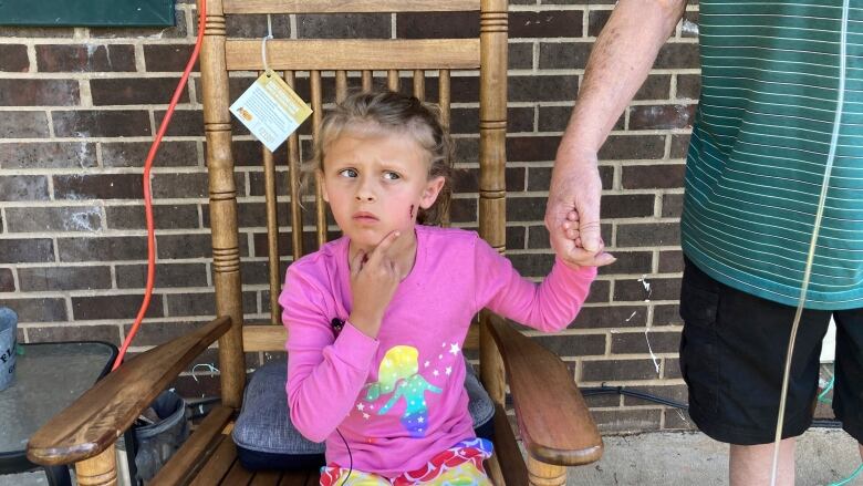 A six-year-old girl in North Carolina, shows reporters a wound on her face.