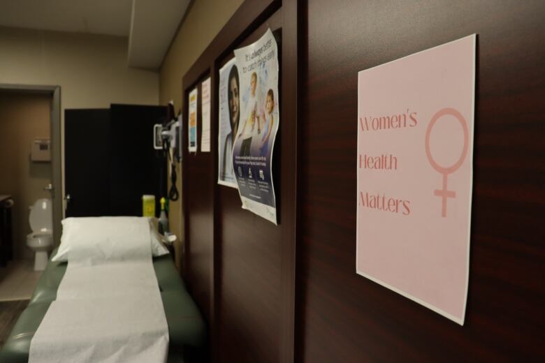 A sign reads 'Women's Health Matters' and it hangs beside a bed for patients.