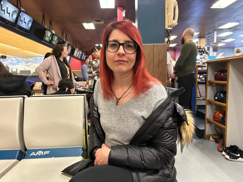 A woman sits on a bench.