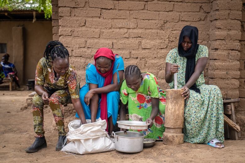 Four woman in a row are eating