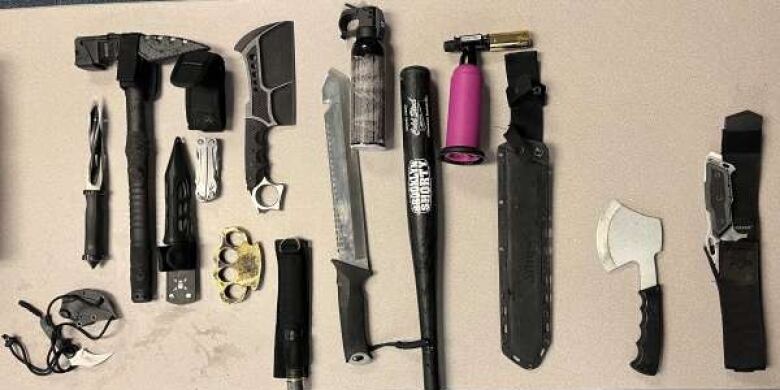 A police presentation shows knives, hammers and small weapons on a table.