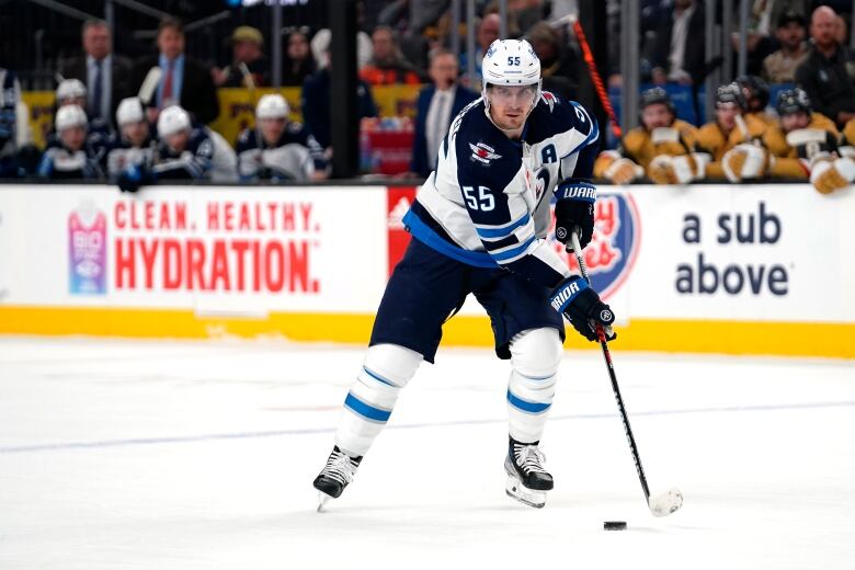 A hockey player controls the puck mid-game.