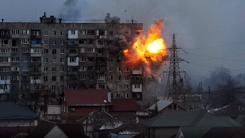 A fiery explosion in the upper floors of an apartment building is shown. 