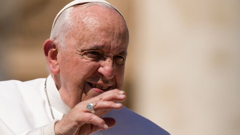 The pope gestures.