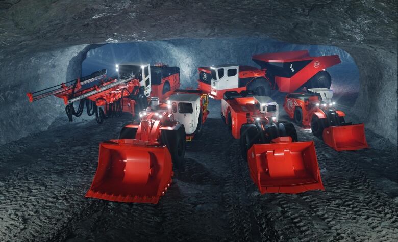 A photo of five battery-electric vehicles in a dimly lit underground mine.