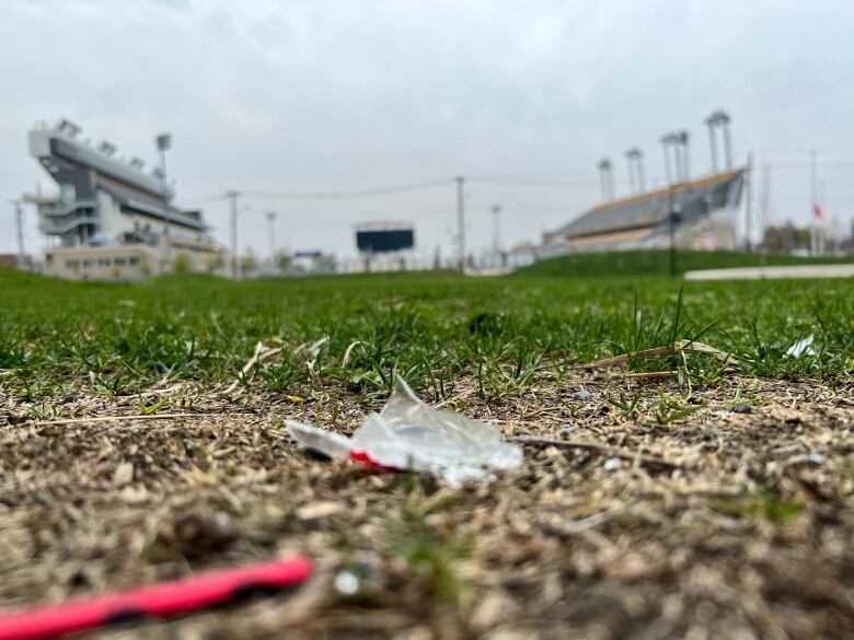 A small piece of glass on the ground. A stadium stands in the background.