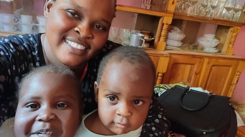 A woman is pictured with two young children.