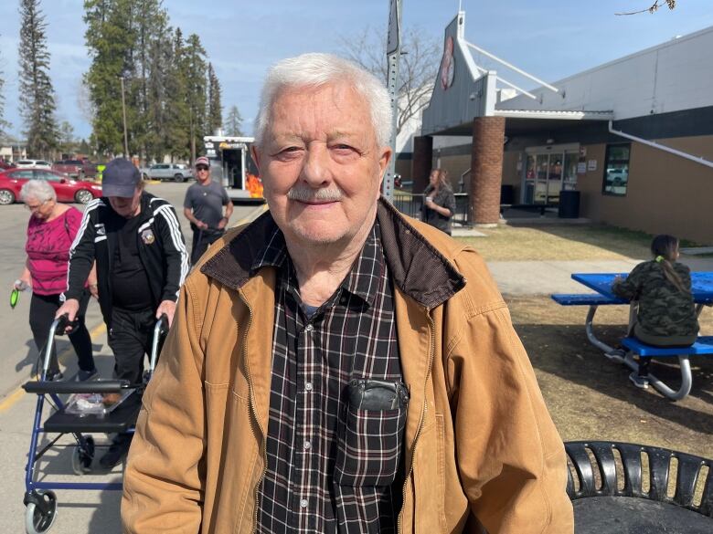 Older man in Jacket looks at camera outside Edson Leisure Centre being used as an evacuation reception.