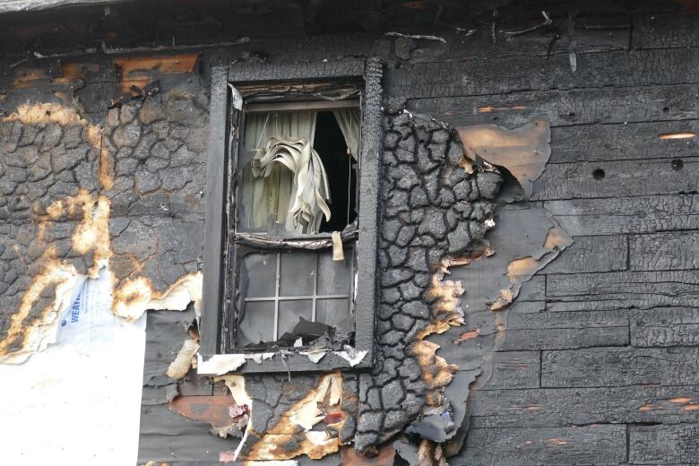 Close up shot of window of fire damaged home.