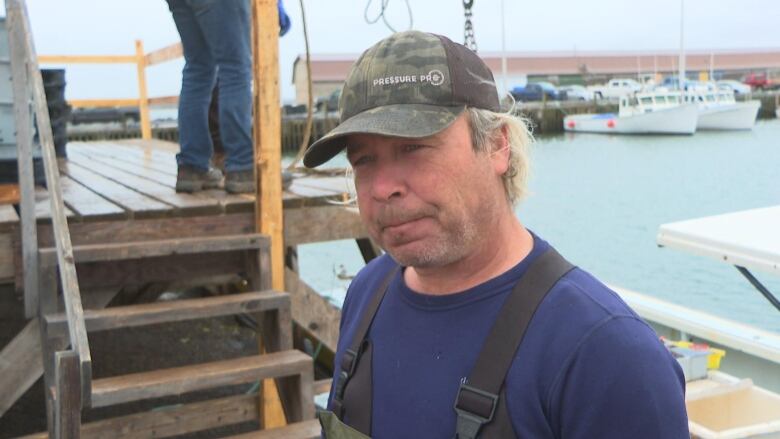 A man in a cap looks at the camera