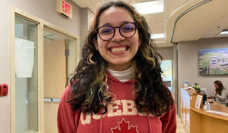 A woman with glasses smiling.