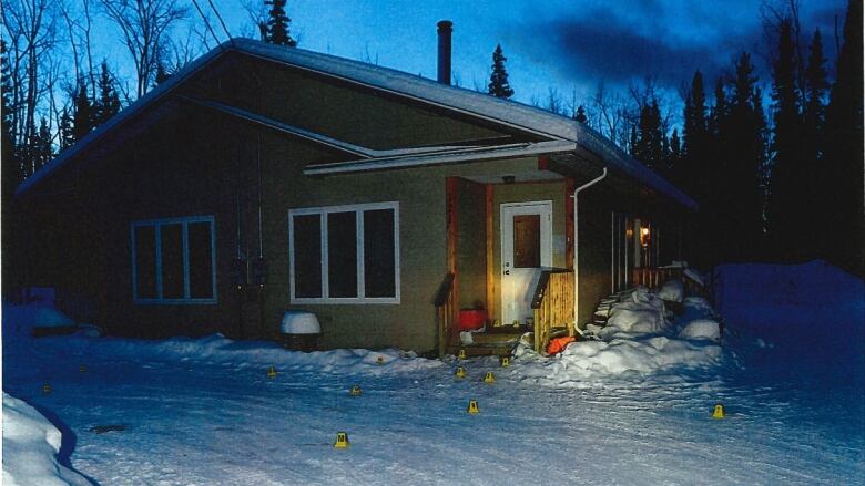 A house surrounded by snow-covered ground. Several bright-yellow evidence markers are placed from the front door to the driveway. 