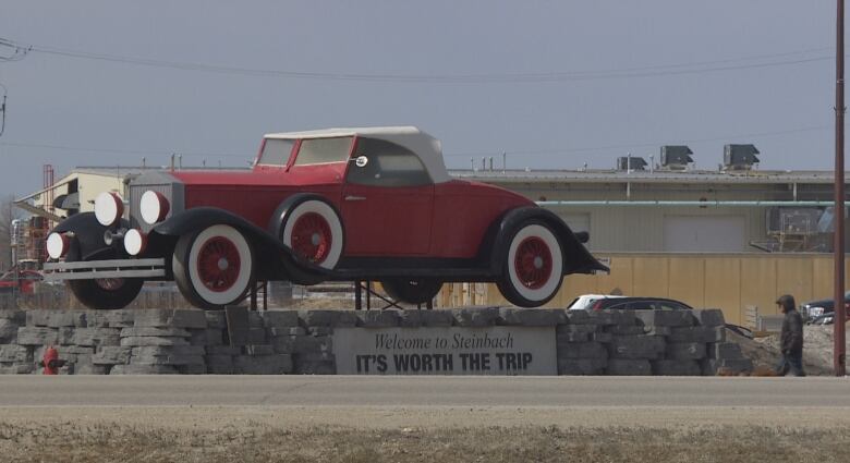 A statue of a giant red car, as seen in the city of Steinbach.