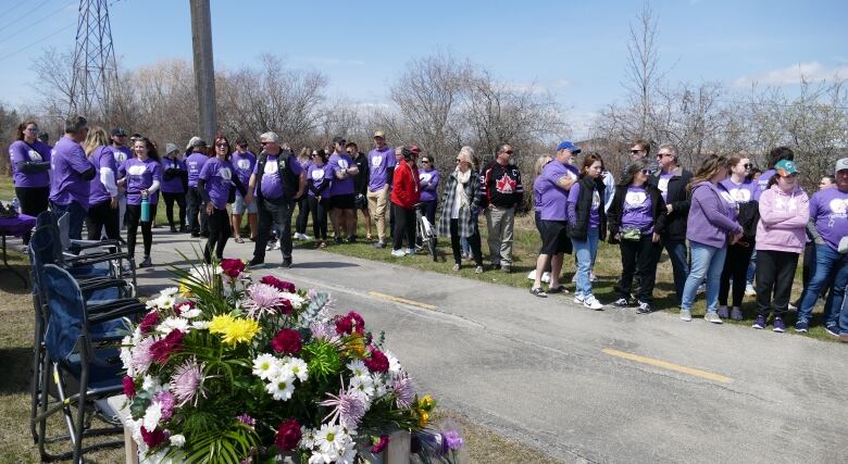 A group of people wearing purple shirts are pictured.