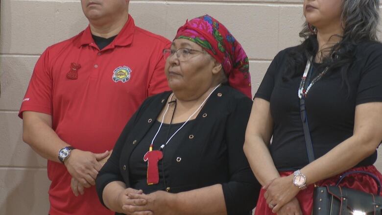 A woman wearing a necklace with a Red Dress pendant is pictured.