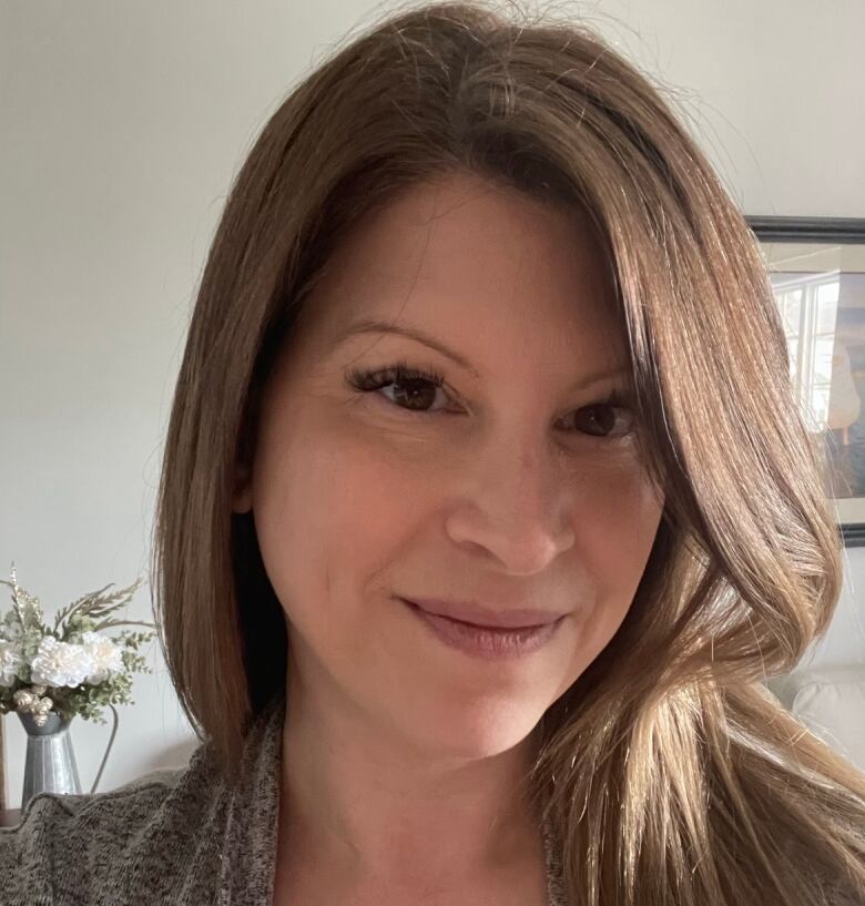 A woman with light brown hair smiles for a photo. 