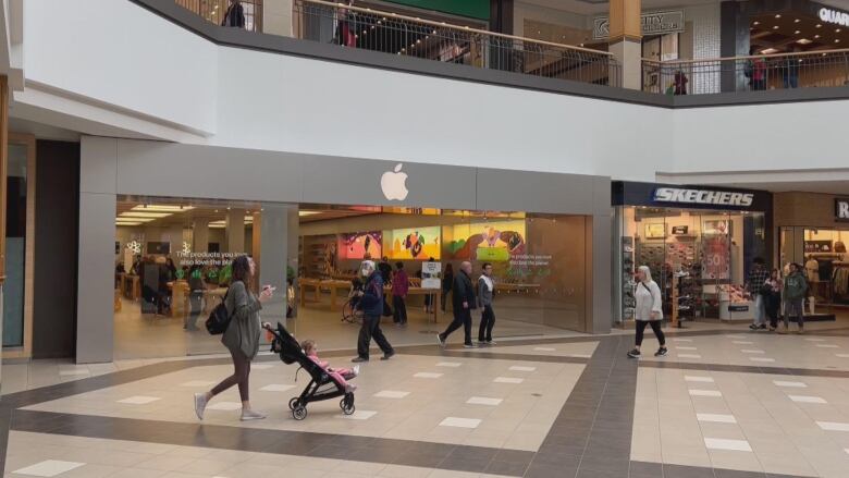 Shoppers walk through a mall.